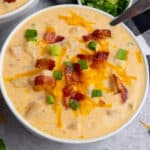 Crock-Pot potato soup in a white bowl with cheese and bacon on top.