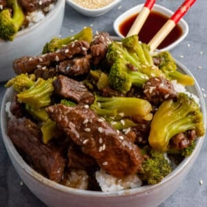 Close up of Crock Pot beef and broccoli in a bowl garnished with sesame seeds.