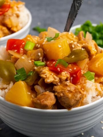 Crock pot Hawaiian chicken on top of a bowl of rice.