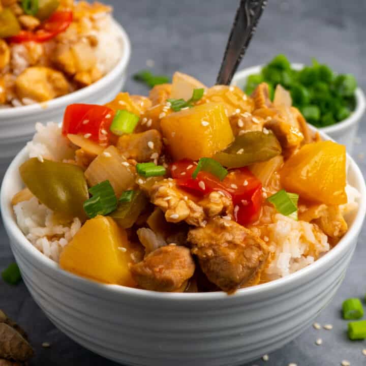 Crock pot Hawaiian chicken on top of a bowl of rice.