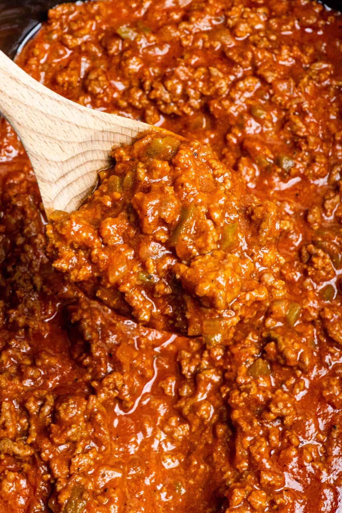 Sloppy joes on a wood spood over a slow cooker.