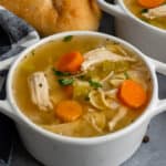 Close up of Crock Pot chicken noodle soup in a white bowl.