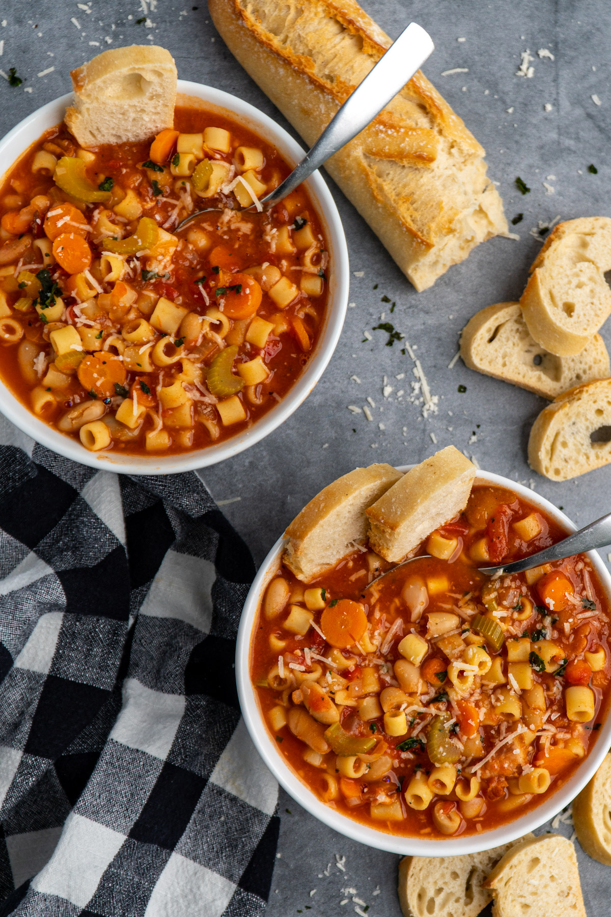 Two bowls of Crock-Pot pasta fagioli with slices of baguette in them.
