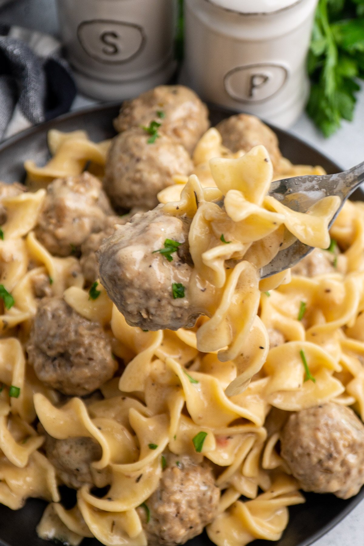 Swedish meatballs on a fork over noodles.