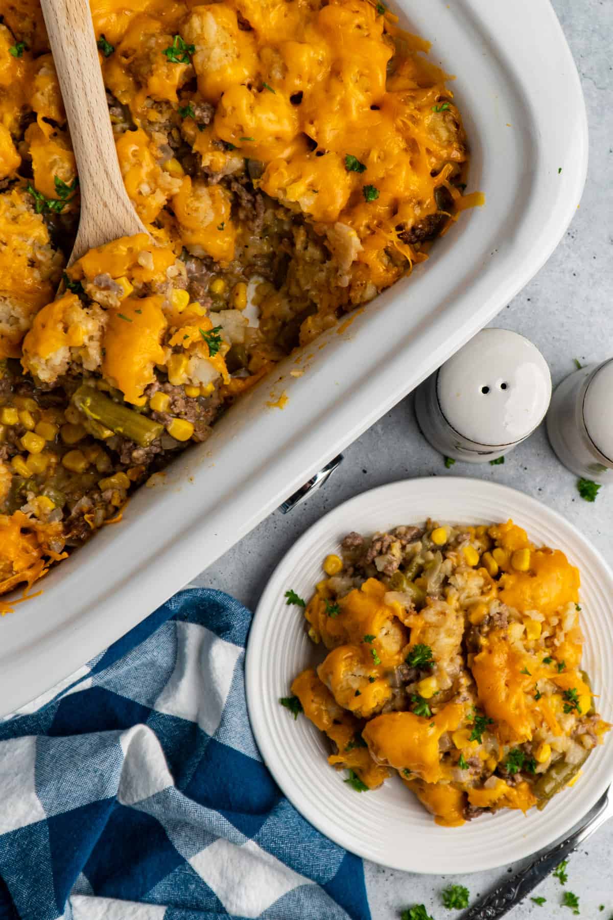 Overhead look at crock pot tater tot casserole in a slow cooker and on a white plate.