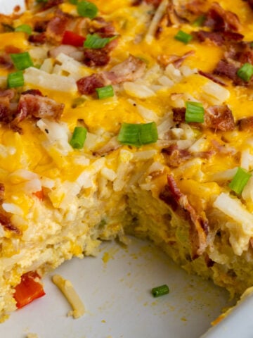 Crock pot breakfast casserole with a portion missing to show off what is inside.