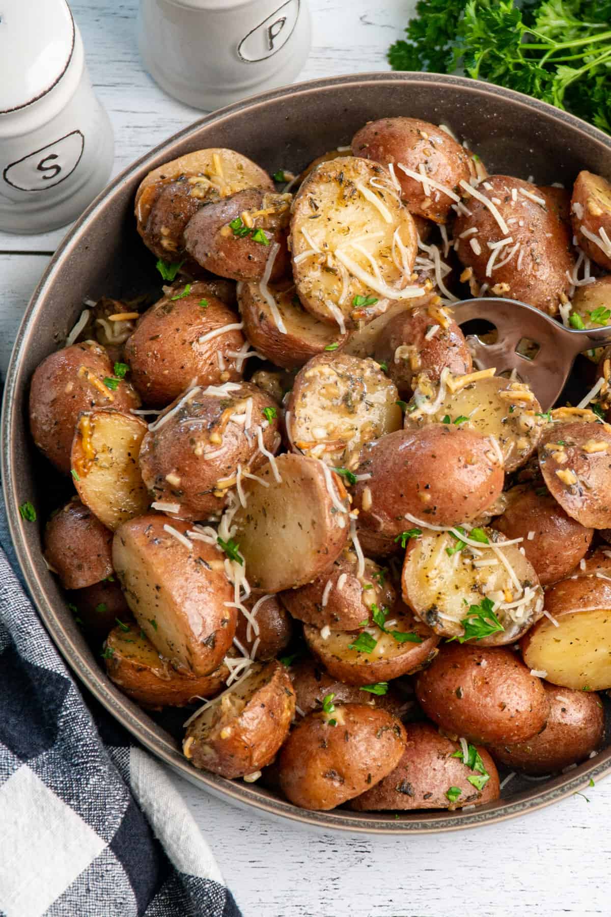 close up of crock pot ranch potatoes in a grey bowl.