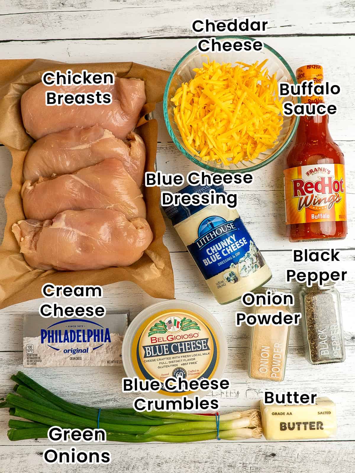 Ingredients to make buffalo chicken dip on a white wood countertop.