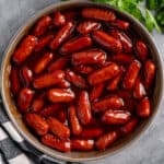 Crock pot little smokies in a gray bowl with bbq sauce.