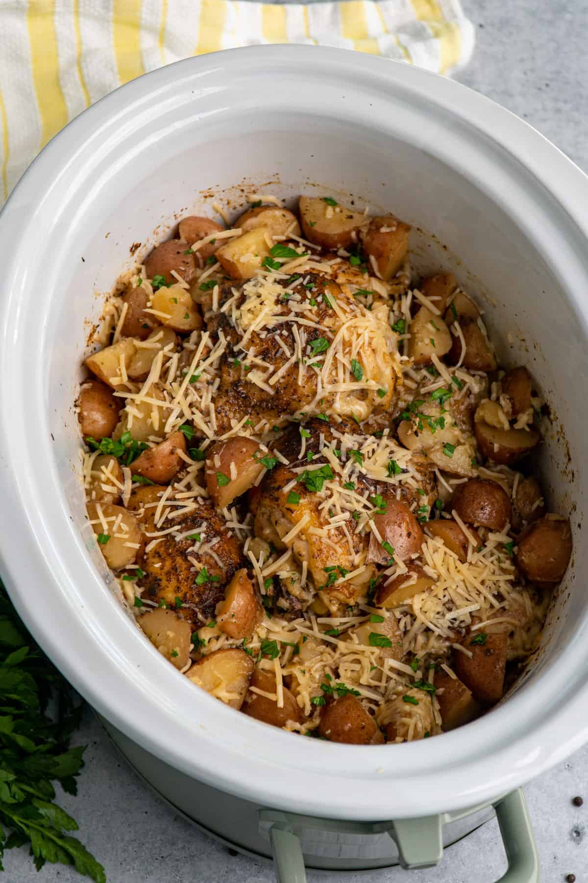 Over head look at slow cooker garlic parmesan chicken and potatoes in a crock pot.