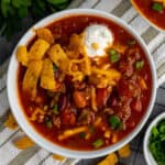 Overhead look at the best Crock Pot Chili in a white bow with toppings.