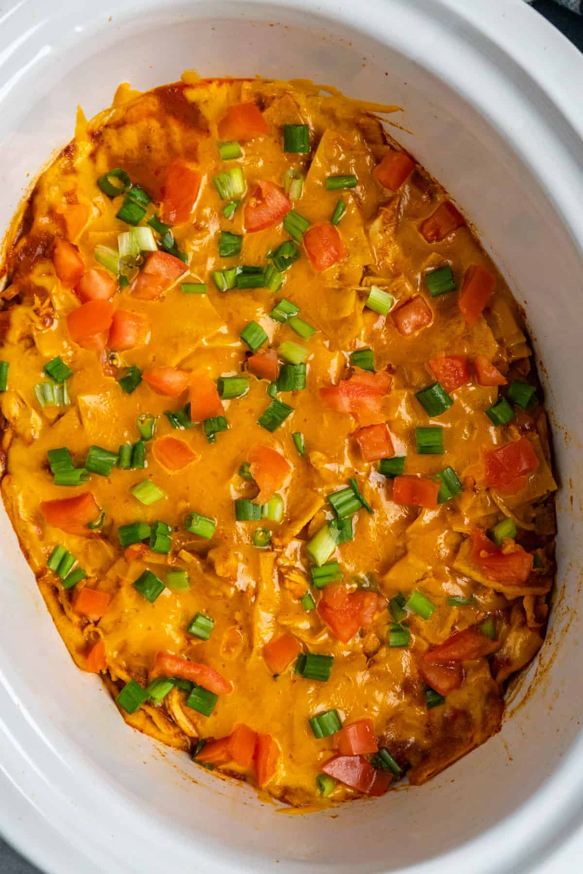 Overhead look at chicken enchilada casserole in a white slow cooker
