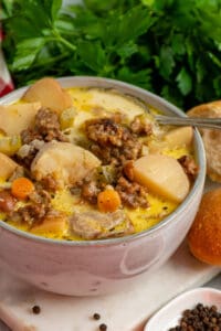Image of crock pot sausage and potato soup in a bowl with a spoon in it.