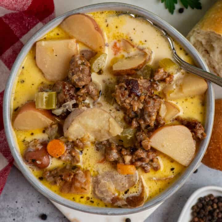 Image of crock pot sausage and potato soup in a bowl with a spoon in it.