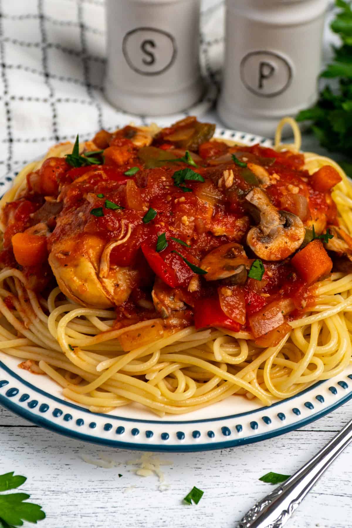 Slow cooker chicken cacciatore on a plate of pasta