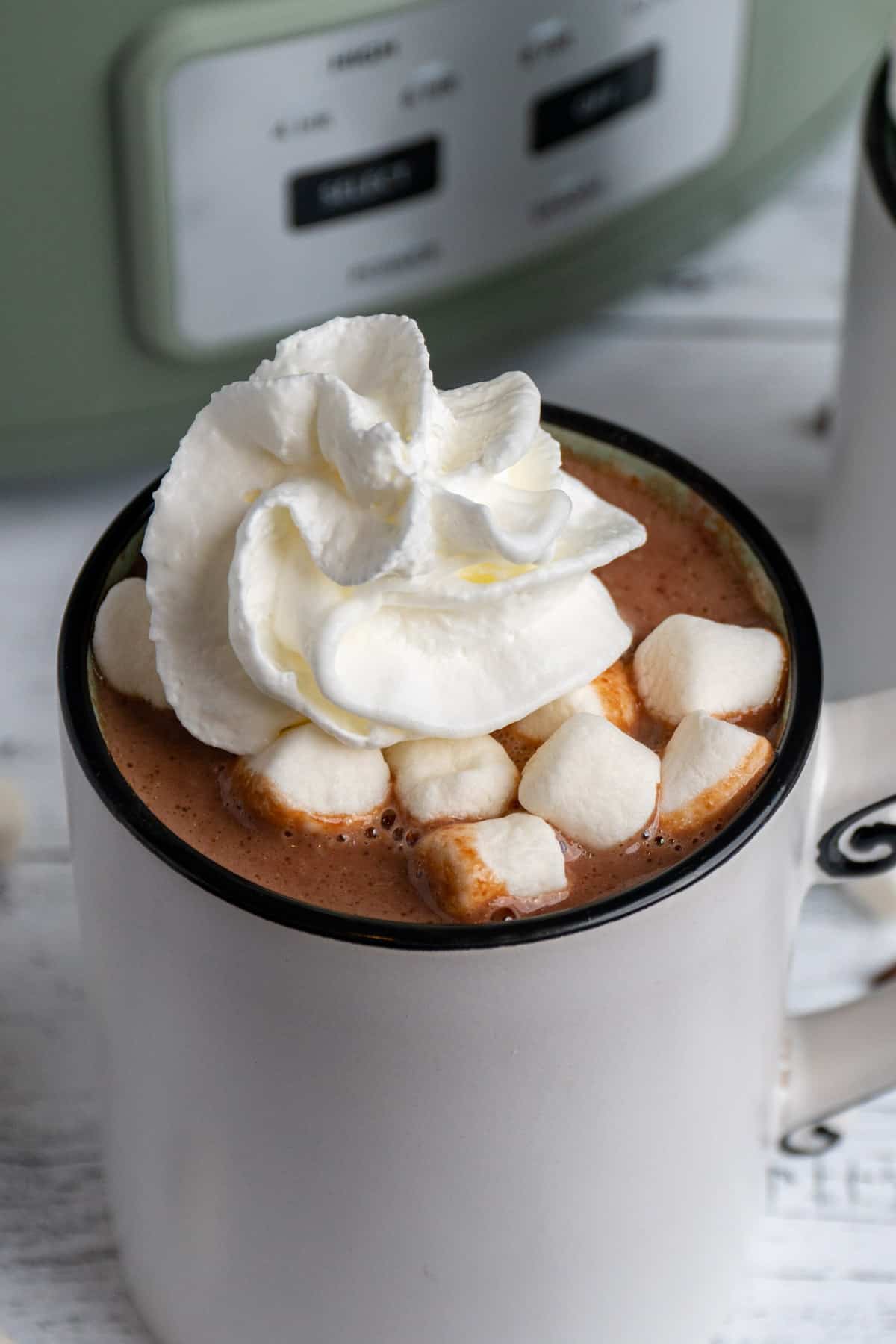 Hot chocolate in a white mug with marshmallows and whip cream on top