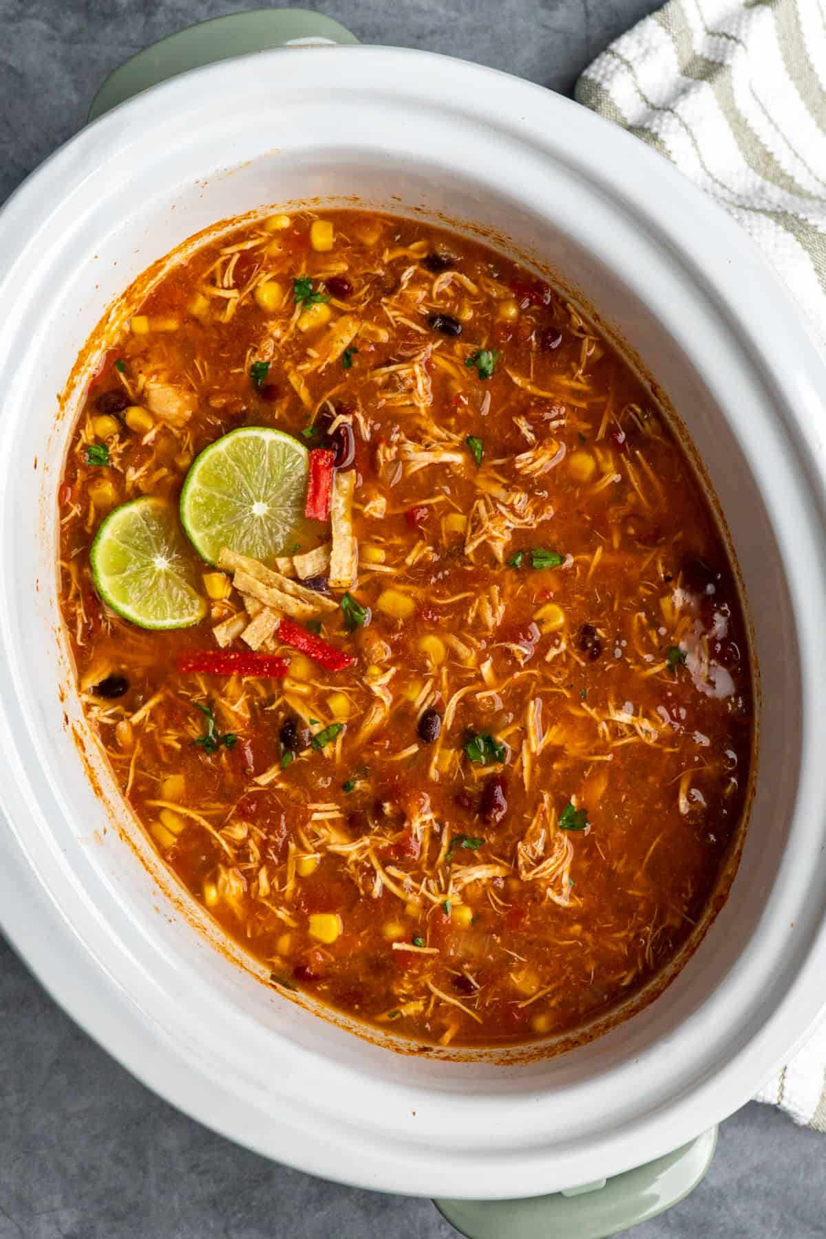 Dump and go slow cooker chicken taco soup garnished with fresh limes.