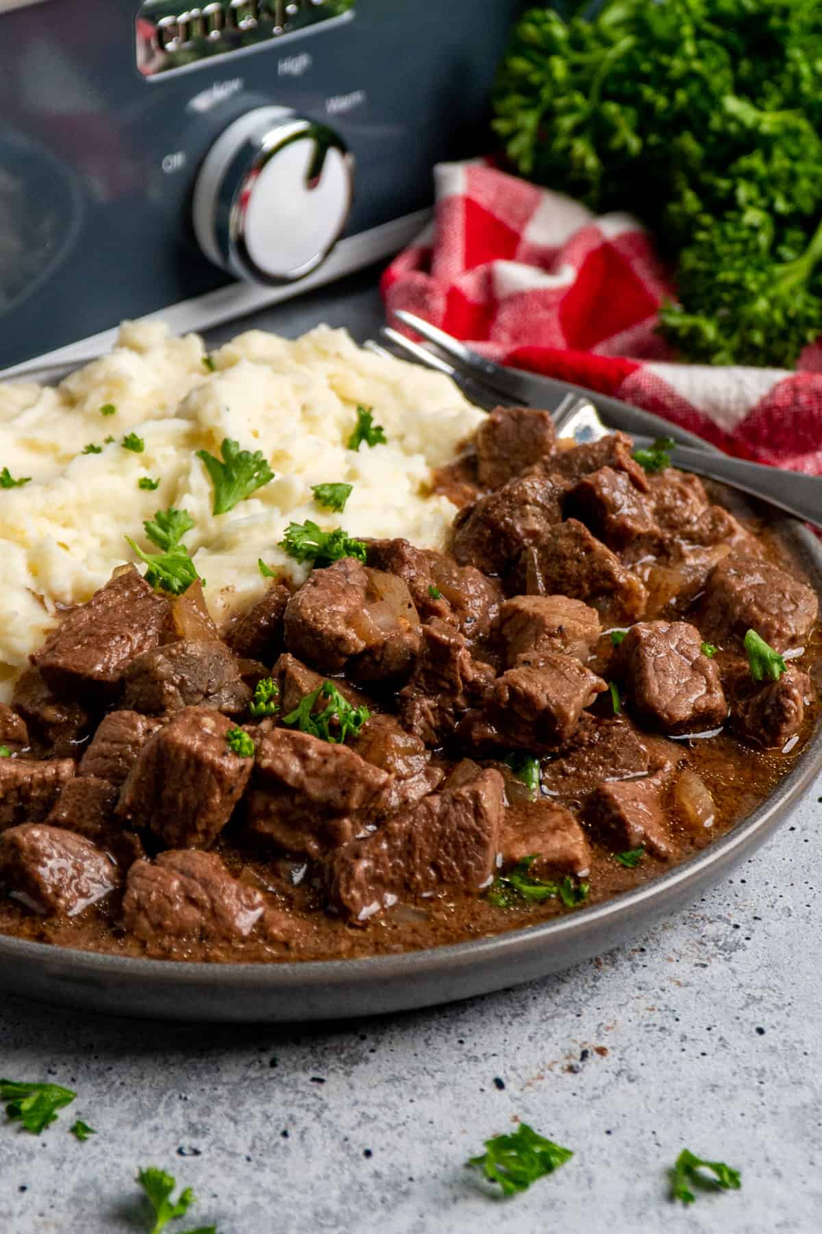 Crock Pot steak bites on a plate with mashed potatoes.