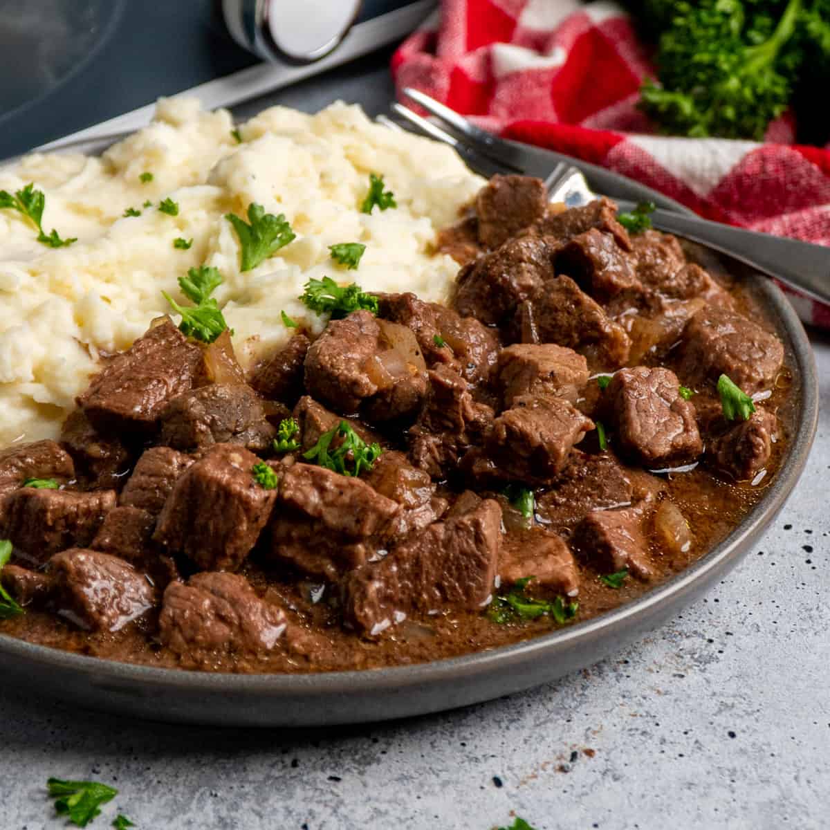 Steak bites on a plate with mashed potatoes.