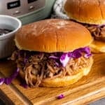 Slow cooker Hawaiian pulled pork on a bun and topped with cabbage.