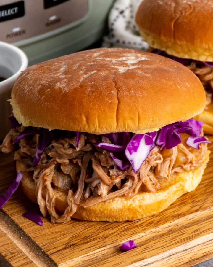 Slow cooker Hawaiian pulled pork on a bun and topped with cabbage.