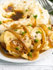 Crock Pot French onion chicken on a plate with mashed potatoes.