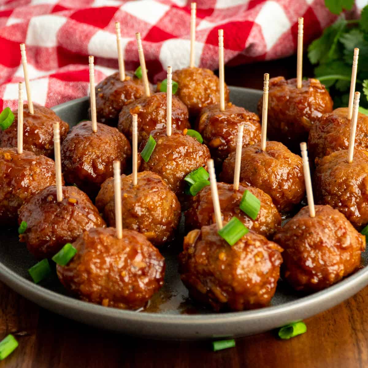 Honey garlic meatballs on a plate with toothpiks in them.