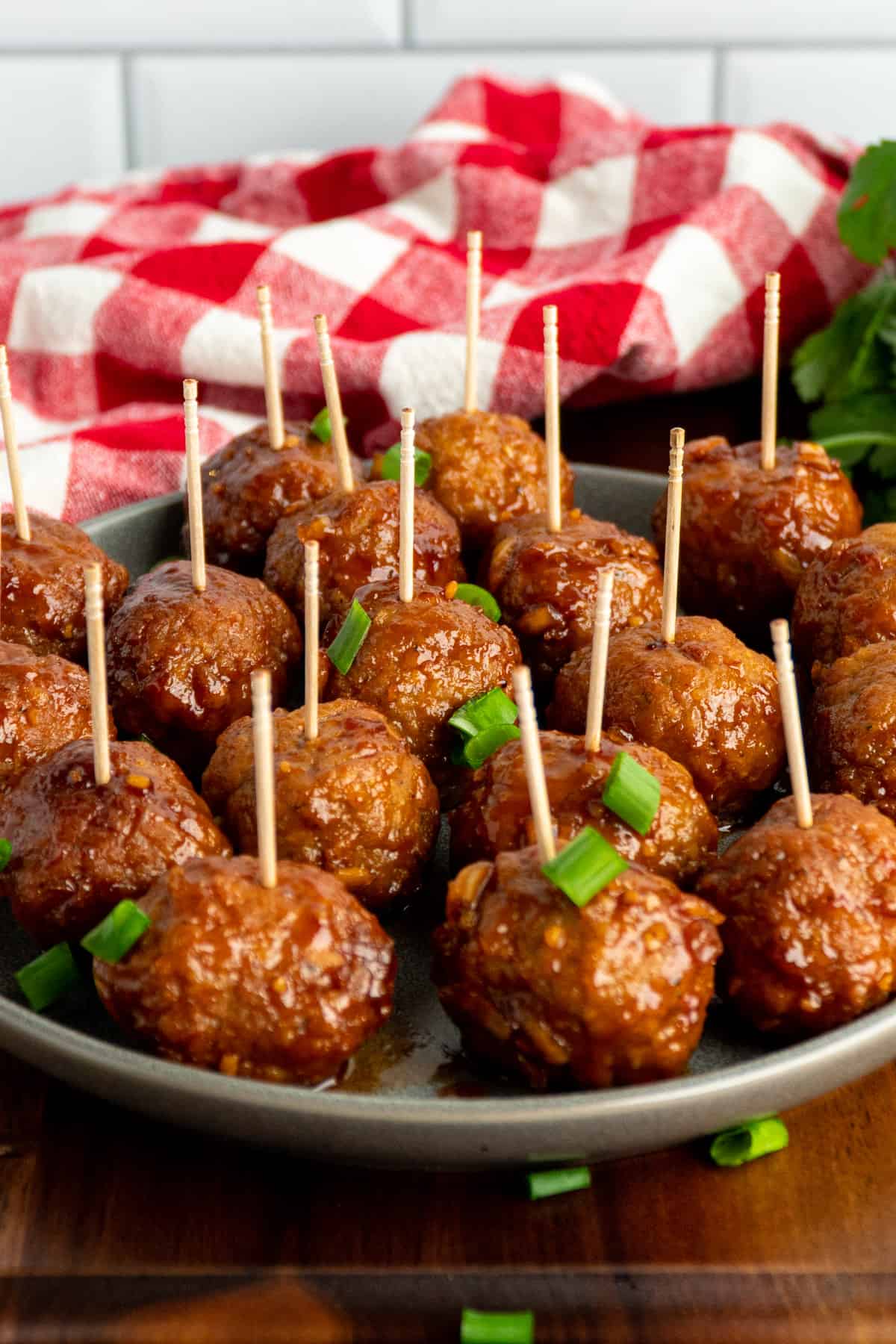 Crock pot honey garlic meatballs on a plate with toothpicks in them.