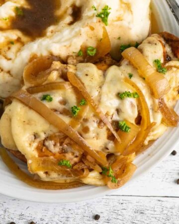 Crock Pot French onion chicken on a plate with mashed potatoes.