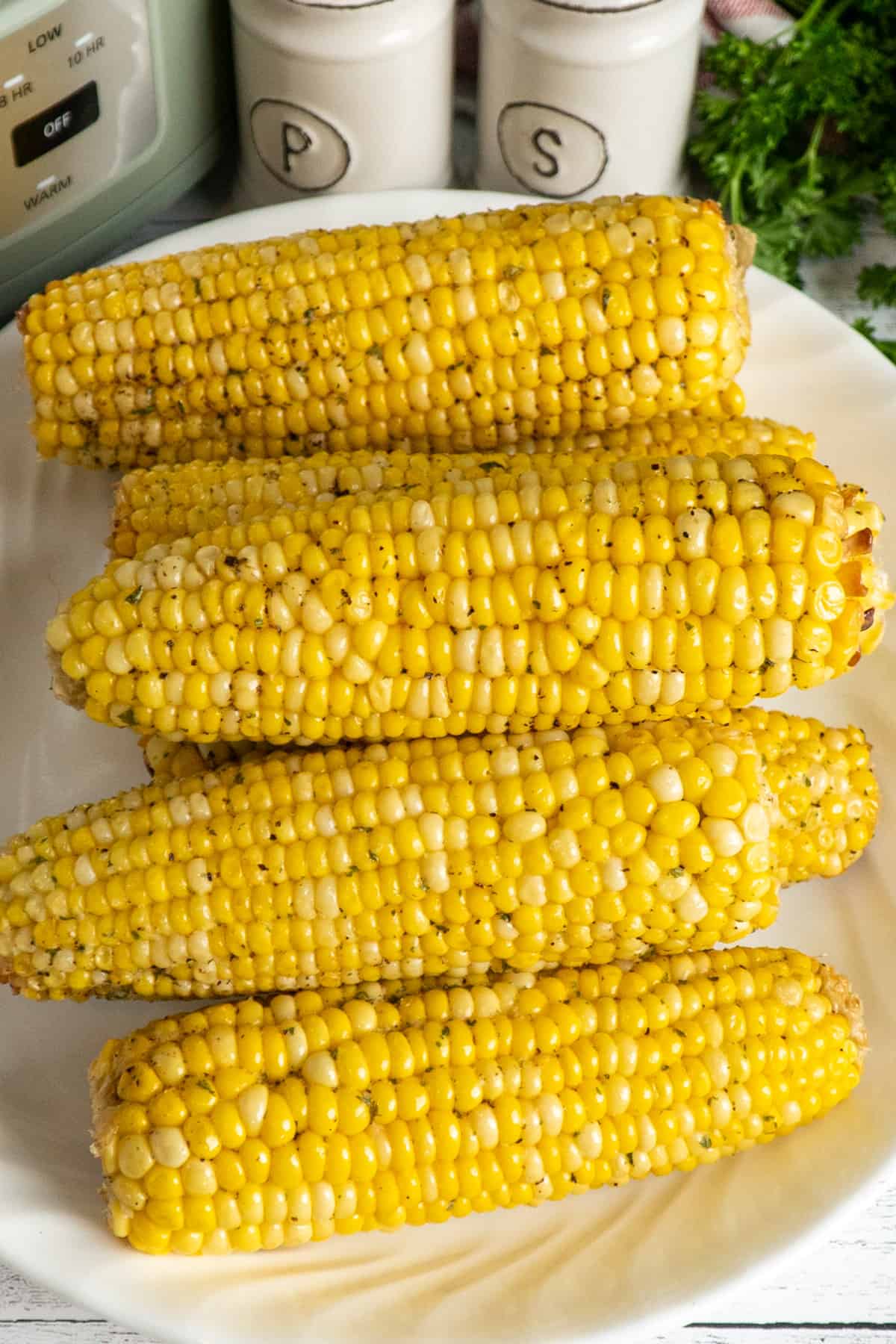 Corn that has been seasoned and buttered on a plate.