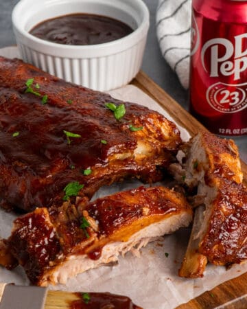 Close up of crock pot Dr. Pepper ribs on a wood cutting board.