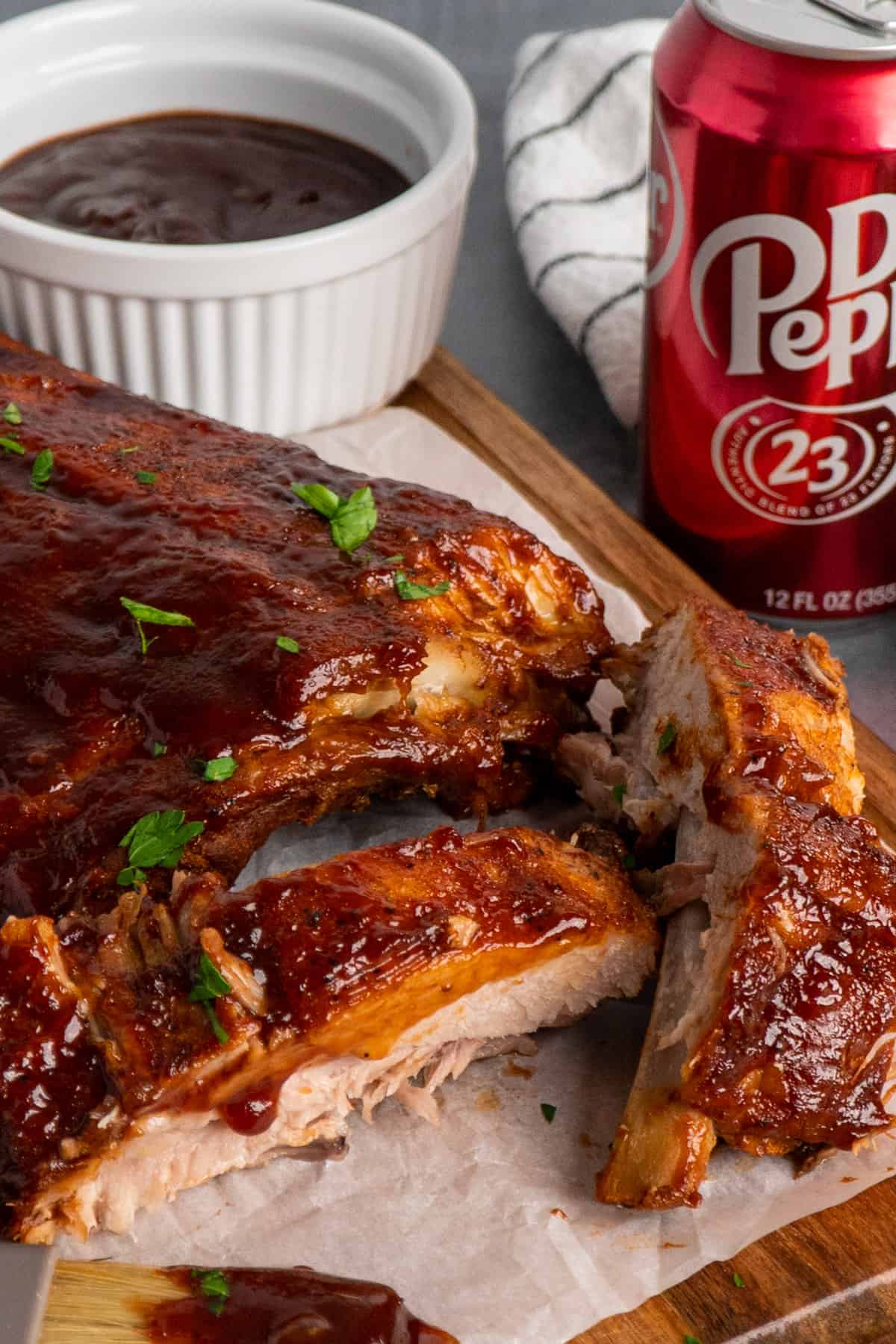 Close up of crock pot Dr. Pepper ribs on a wood cutting board.