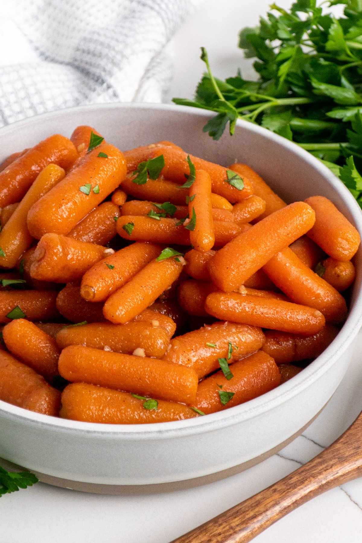 A side view of honey glazed carrots in a bowl.