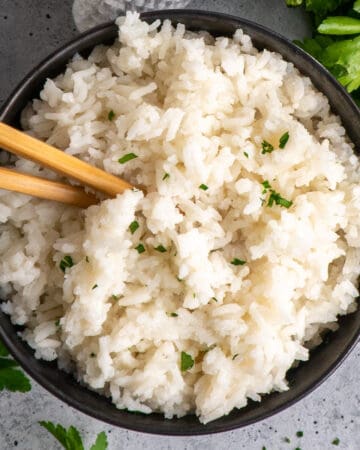 Overhead look at crock pot rice in a bowl with chopsticks.