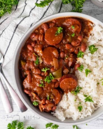 A white bowl with red beans and rice on white wood background.