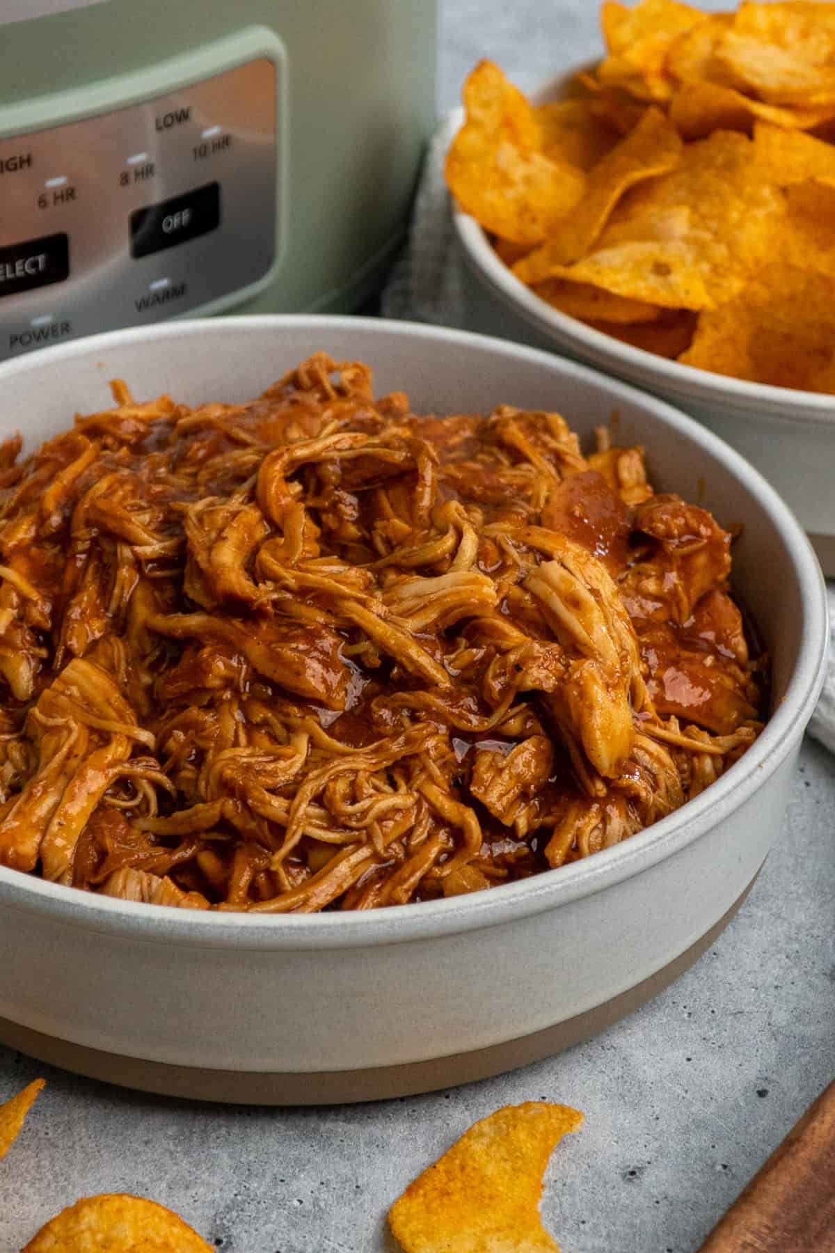 Close-up of bbq pulled chicken in a gray bowl.