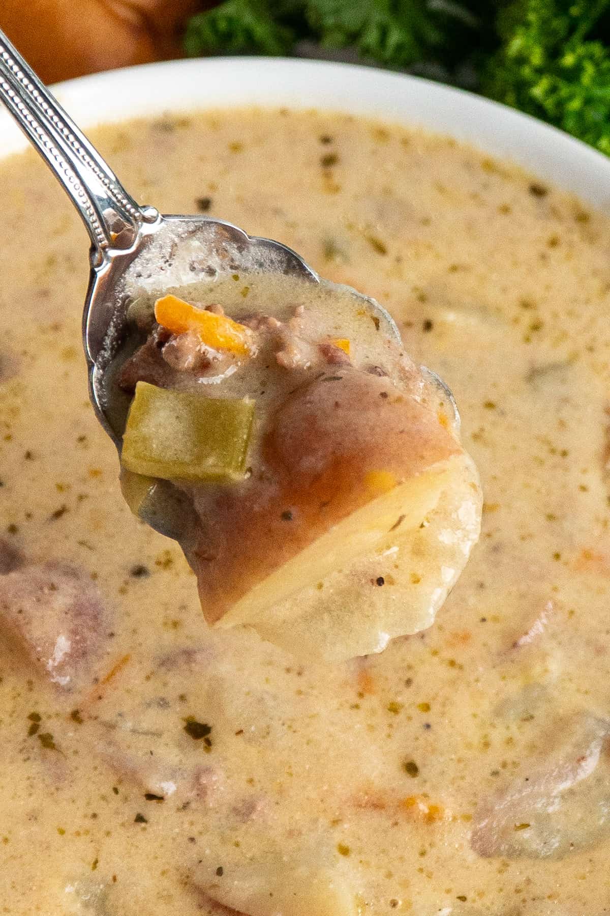 Close up of cheeseburger soup on a spoon.
