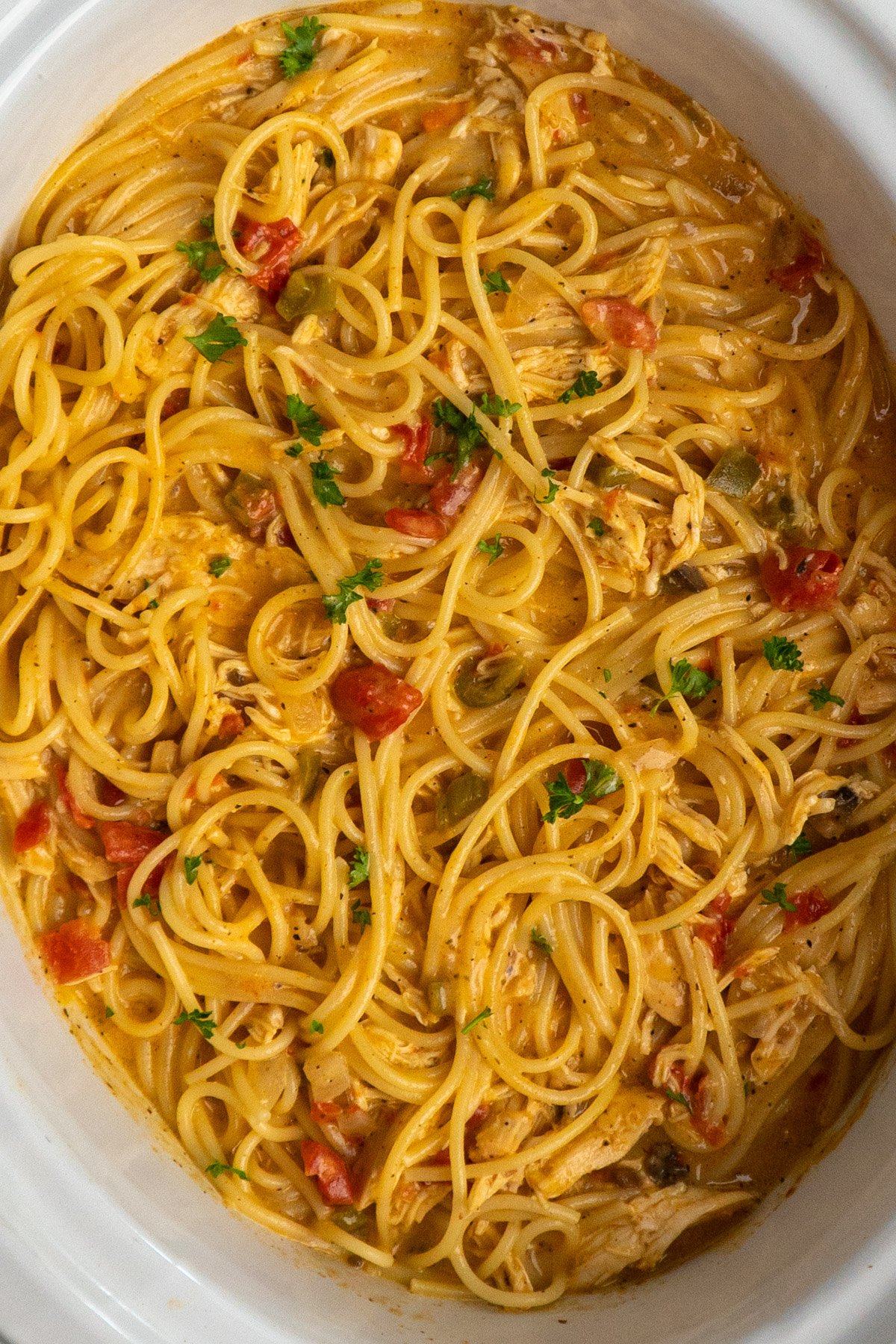 An overhead look at chicken spaghetti in a slow cooker.