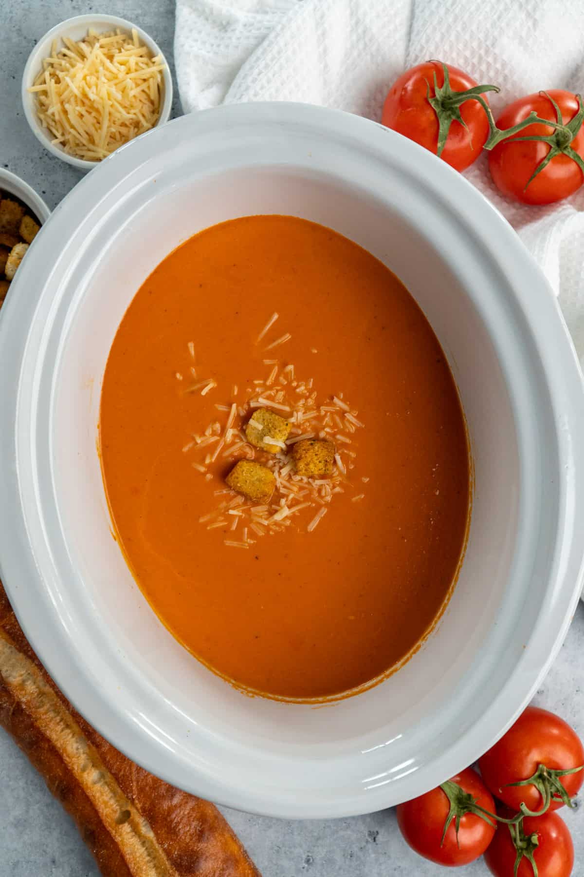 Overhead look at tomato soup in a white slow cooker.