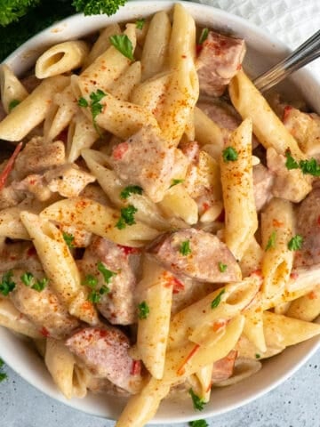 Close-up of crock pot cajun chicken pasta in a white bowl.