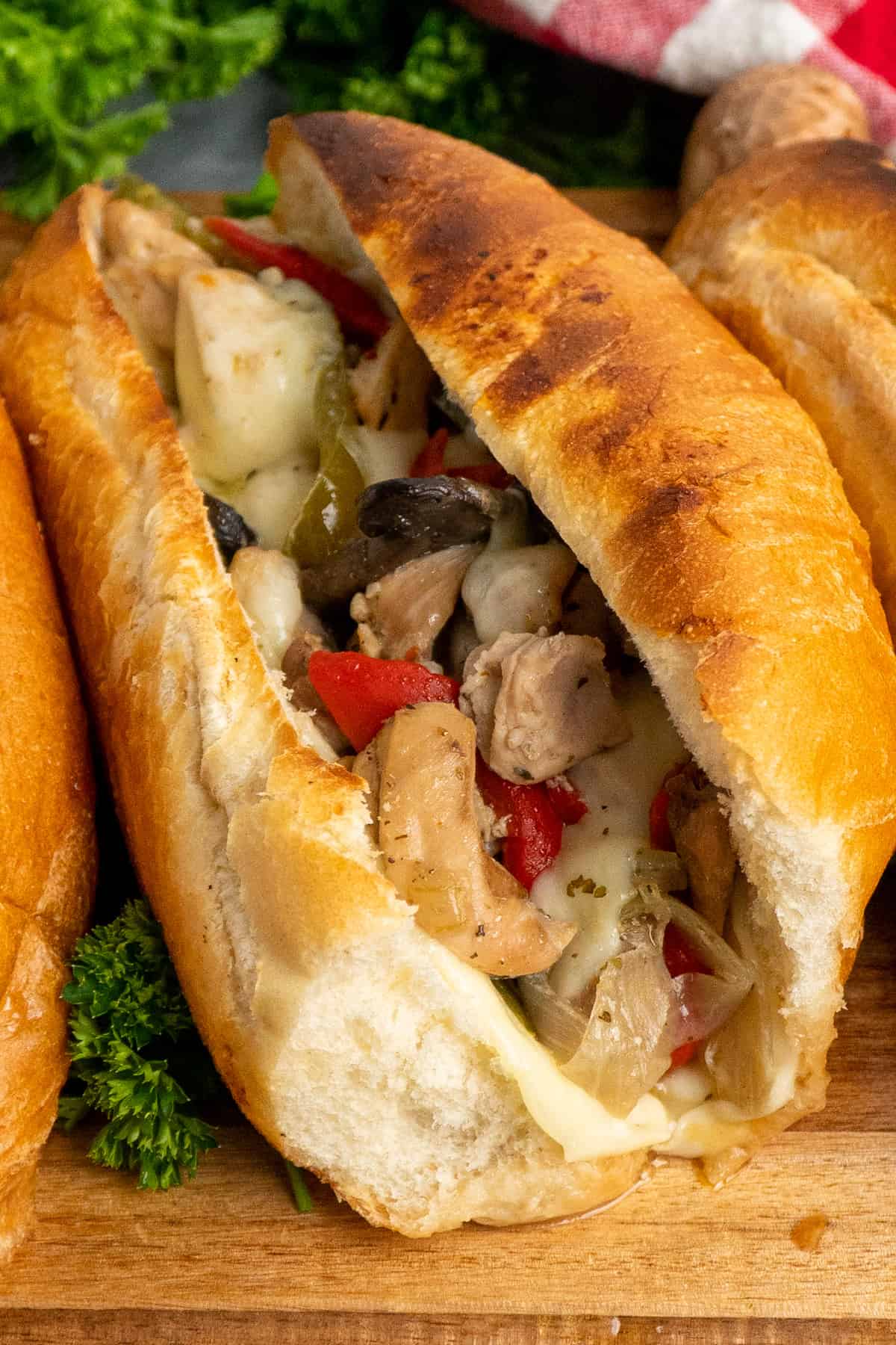 Close-up of chicken philly cheesesteak on a toasted bun.