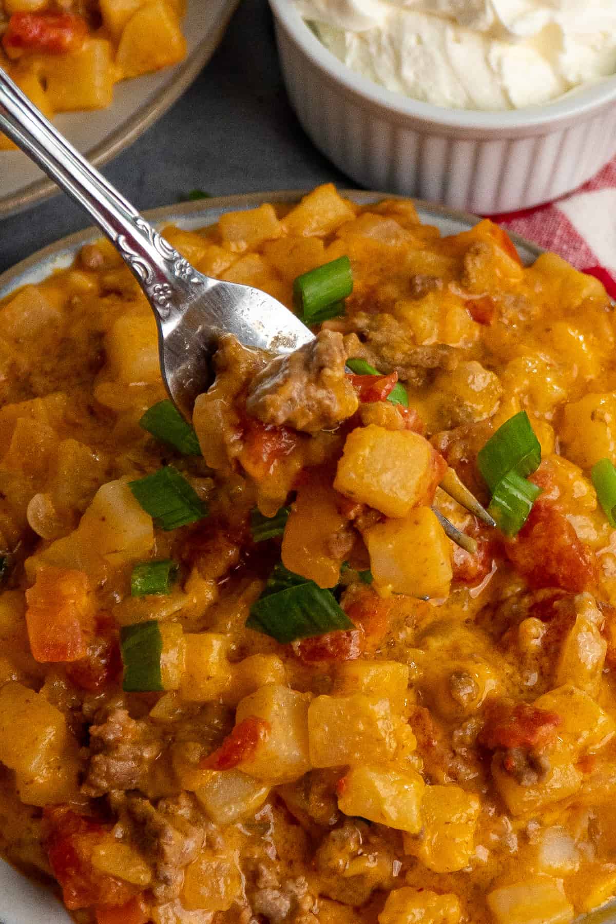 A fork holding a bite of beefy potato taco casserole.