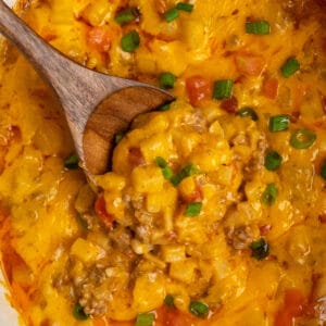 Close-up of crock pot beef potato taco casserole with a wooden spoon in it