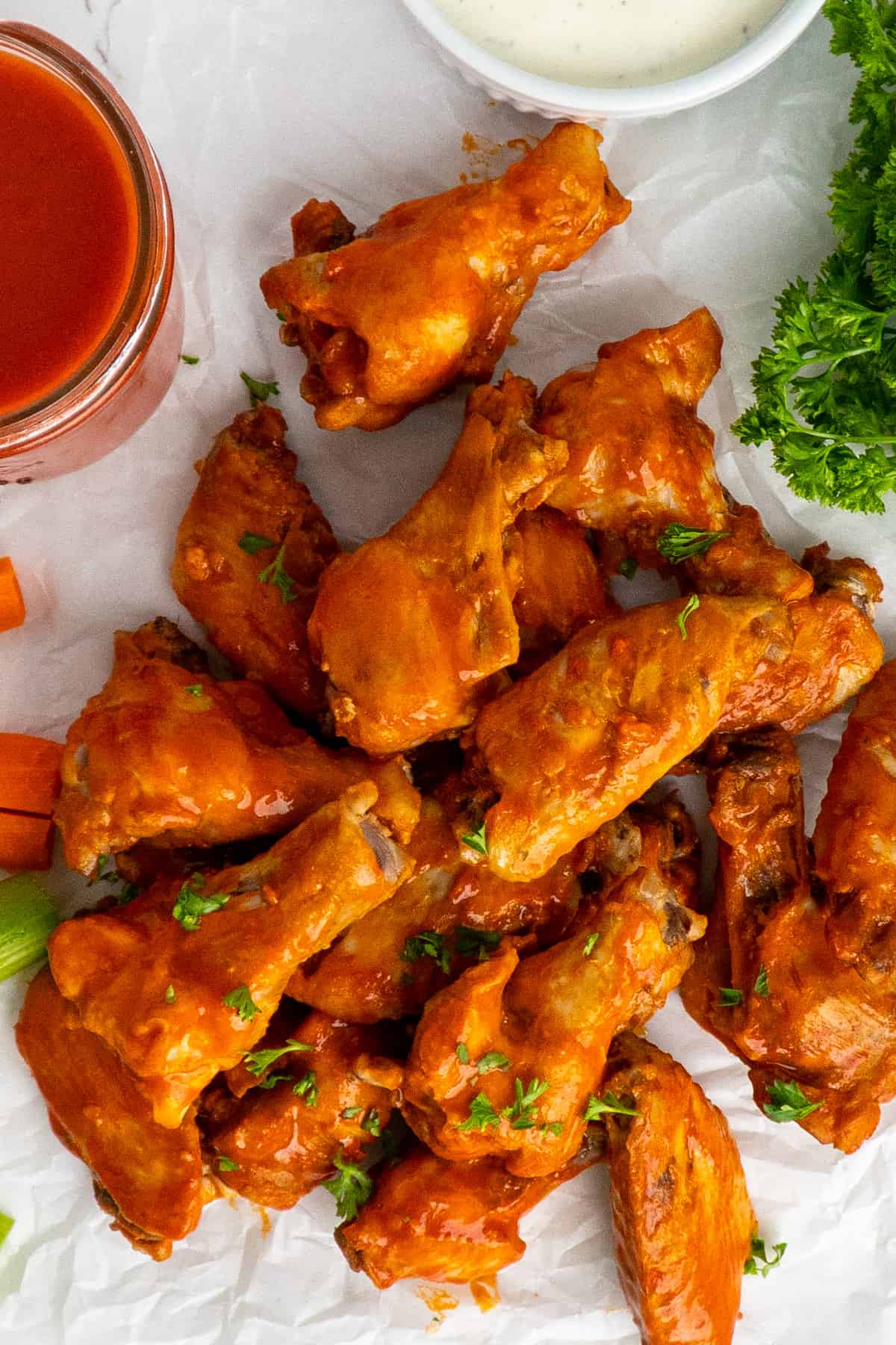 Buffalo chicken wings on a piece of parchment paper.