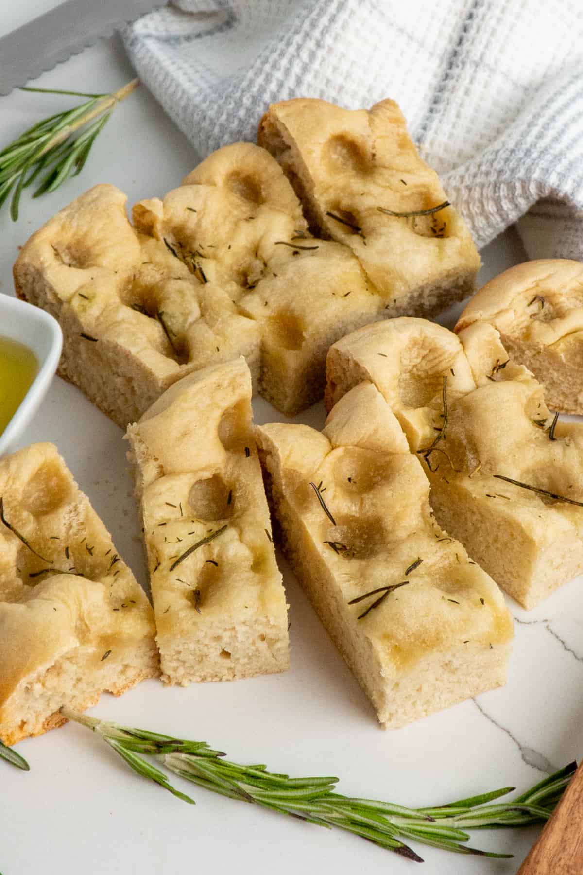 Foccacia bread cut up on a white countertop.