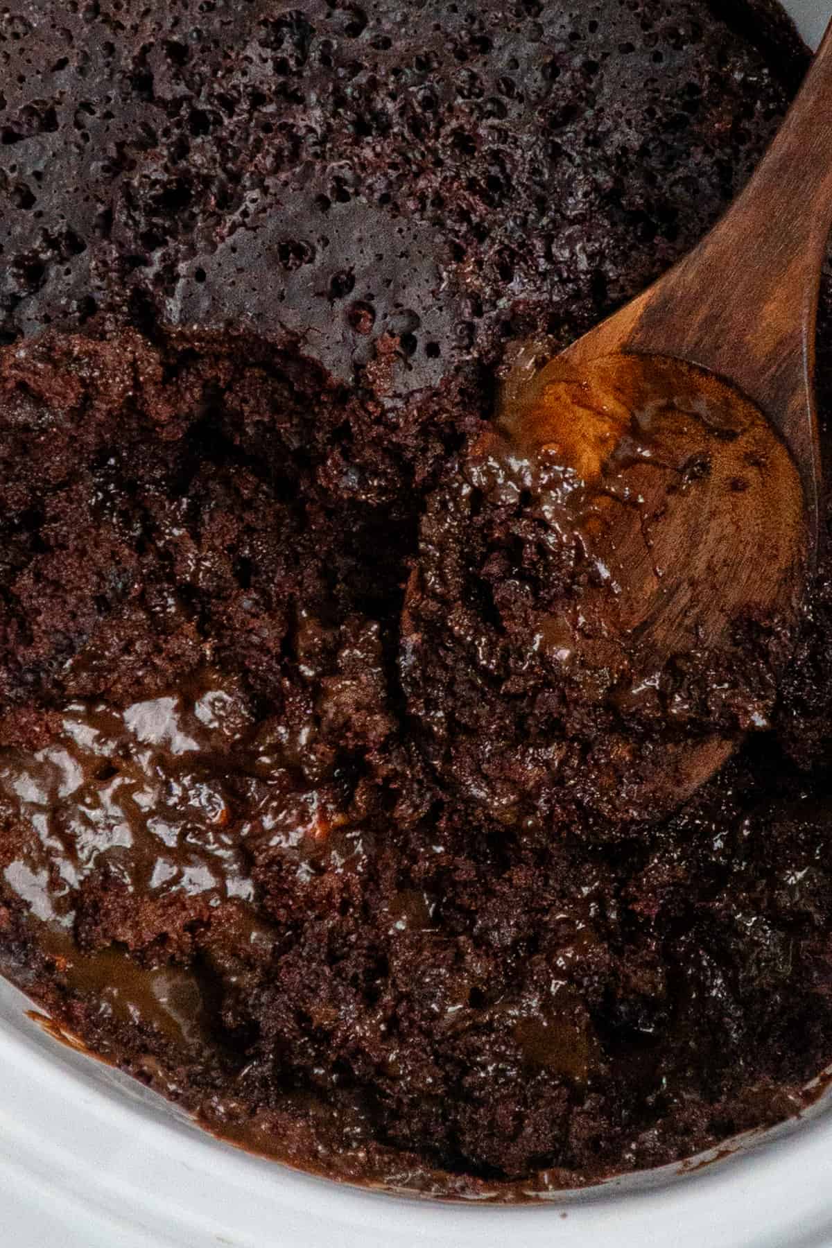 Overhead, look at crock pot chocolate lave cake with a wooden spoon in it.