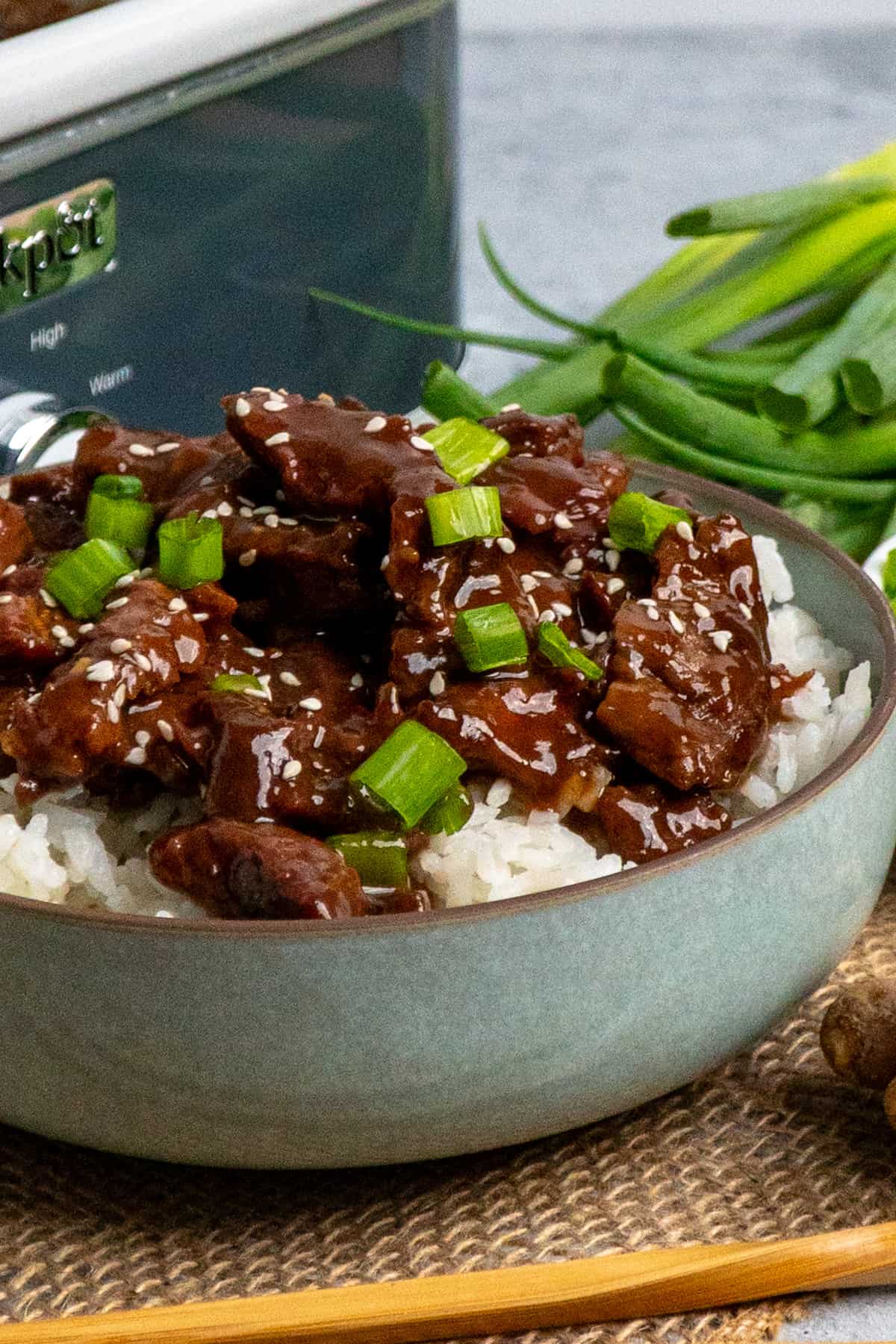 Close up of Korean beef over a bowl of rice.
