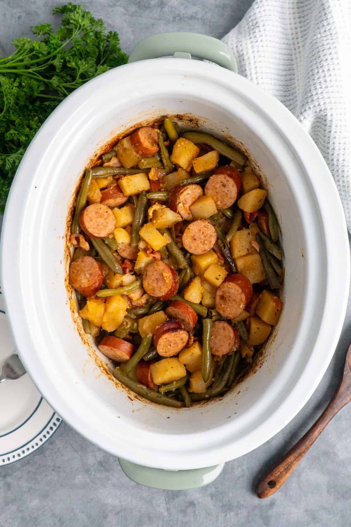 Overhead look at sausage potatoes and green beans in a crock pot