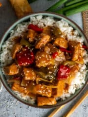 Overhead look at crock pot sweet and sour pork over a bowl of rice.