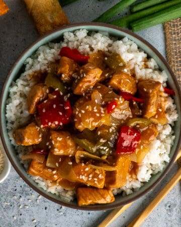 Overhead look at crock pot sweet and sour pork over a bowl of rice.